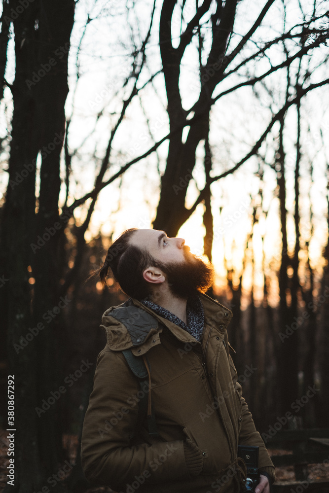 Handsome Bearded Man Standing in a Woods and Looking Up Handsome Bearded Man Standing in a Woods and Looking Up