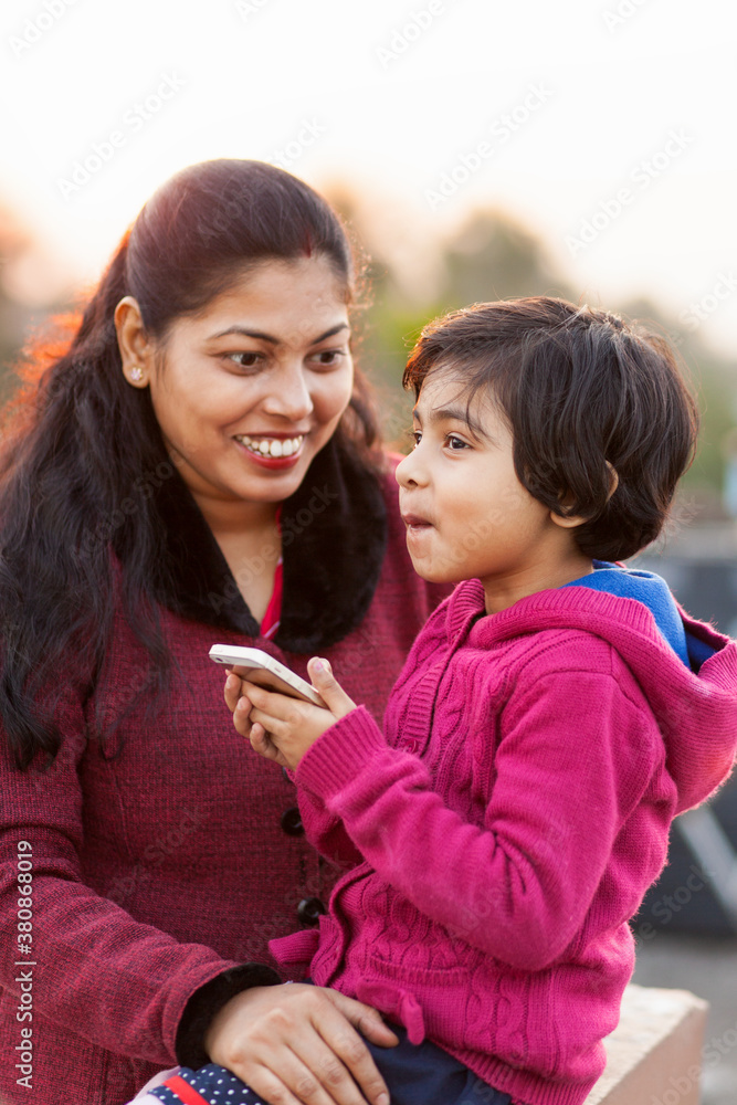 Mother and daughter sharing a cheerful moment outdoors Mother and daughter sharing a cheerful moment outdoors