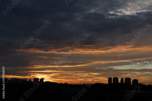 Warm sunset over city skyline with tall buildings in the foreground