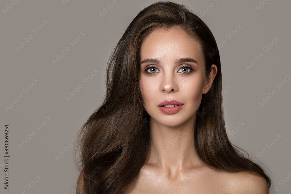Naklejka premium Portrait of a beautiful woman with clean skin make-up and hairstyle. Gray background copycpase