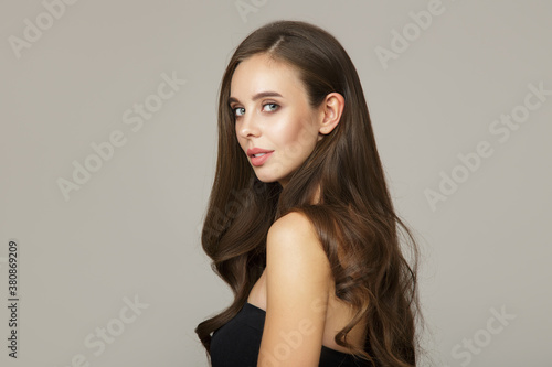 charming brunette with long wavy hair. Hair and face care concept