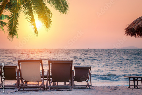 Beautiful sunset beach scene. Chairs on the sandy beach near the sea. Summer holiday and vacation concept for tourism. Inspirational tropical landscape