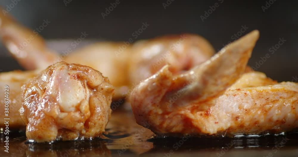 The pan with fried chicken wings rotates. The pan with fried chicken wings rotates.