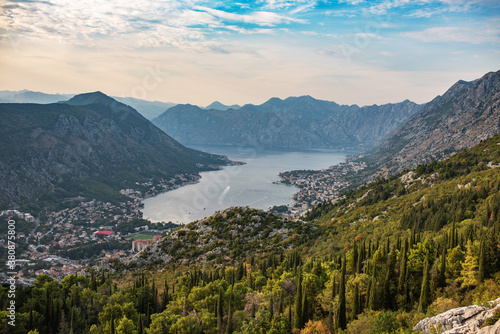 Panorama of Kotor bay and city from mountain road. Picturesque view to Kotor city with lovely architecture and beautiful mountains of Montenegro at sunset.