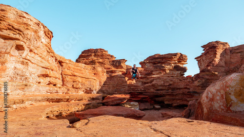 Couple hiking the red and rocky coastline of Broome in Austrlia