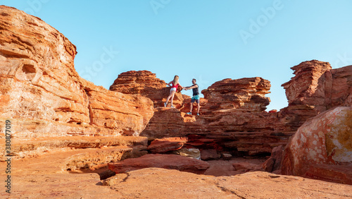 Couple hiking the red and rocky coastline of Broome in Austrlia
