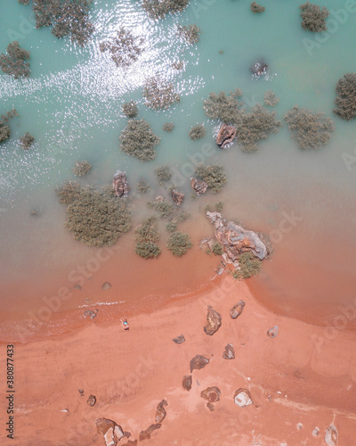 Drone view of red sand beach and turquoise water