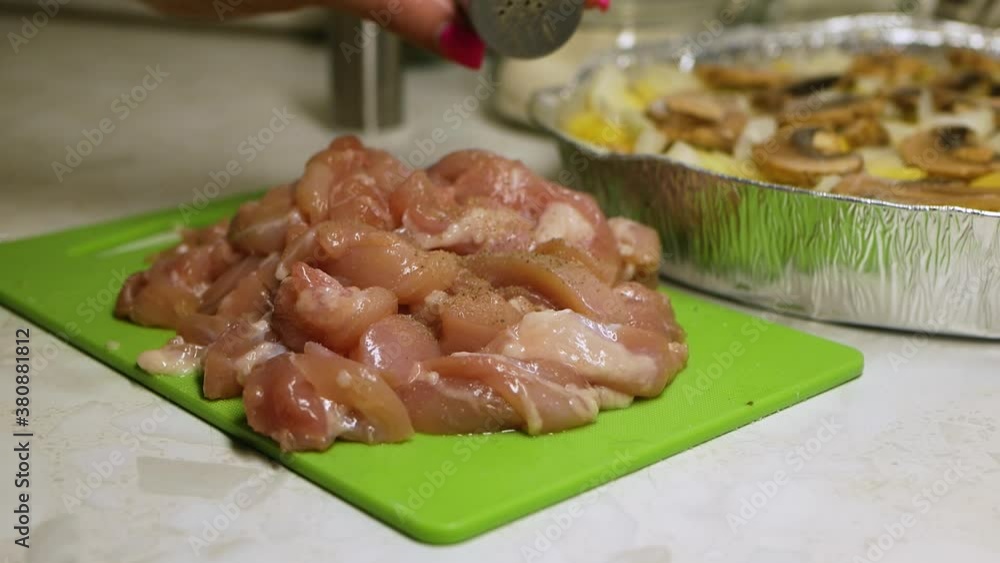 Hand sprinkles the spices on raw meat. Closeup green board Hand sprinkles the spices on raw meat. Closeup green board