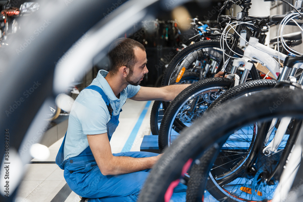 Obraz premium Bicycle shop, repairman looking on new bike