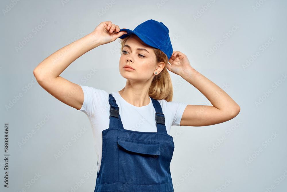 woman in work uniform blue cap service delivery service light background woman in work uniform blue cap service delivery service light background
