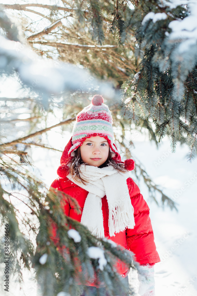 Beautiful young girl wearing bright winter clothes looks at camera sweetly Beautiful young girl wearing bright winter clothes looks at camera sweetly