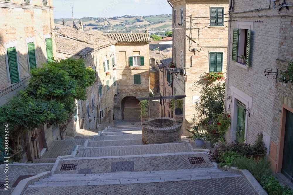 A stairway in a medieval Italian village with an old brick well (Corinaldo, Marche, Italy, Europe)