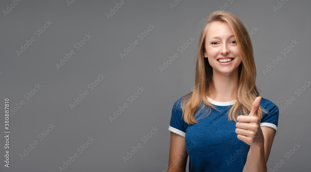 Cheerful girl with blonde straight hair showing OK gesture. Human emotions, facial expression concept. Copy space Cheerful girl with blonde straight hair showing OK gesture. Human emotions, facial expression concept. Copy space