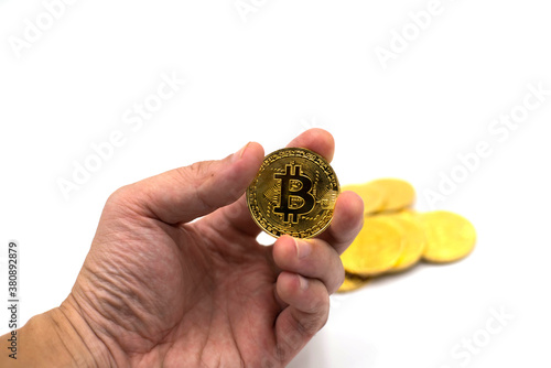 A hand holding Golden bitcoin virtual money on white background.