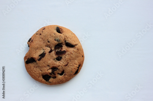Top view of single chocolate chip cookie on white background. Copy space. Selective focus
