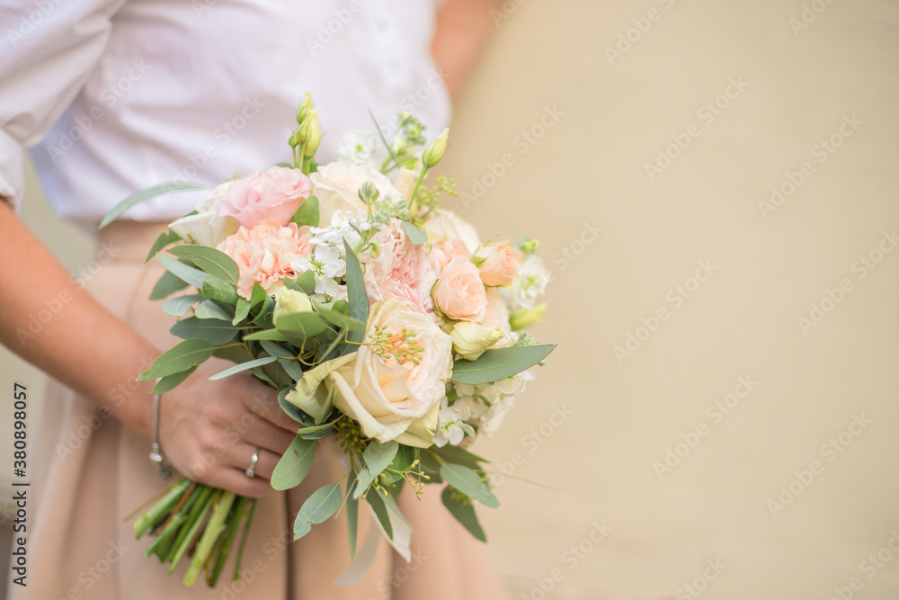 Wedding bouquet in bride hands. Roses, eustoma, eucalyptus in elegant bouquet . Summer and autumn flowers.