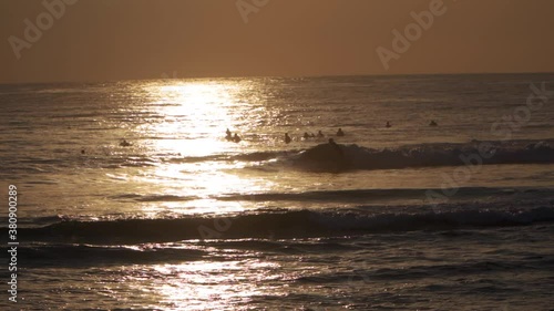 Surfers in silhouette in the late evening - SLOMO photo