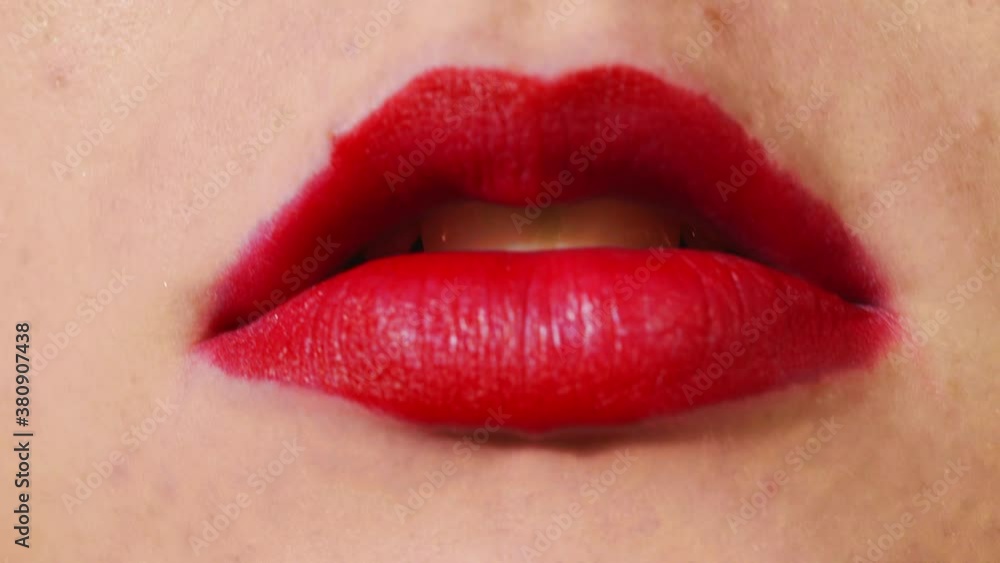 CLOSE UP, red lips blowing cigarette smoke at the camera CLOSE UP, red lips blowing cigarette smoke at the camera
