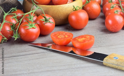 Cherrys tomatoes on branch on wooden table, space for text