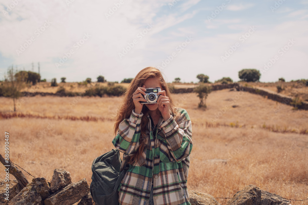 A young girl takes a photo with an analog camera
