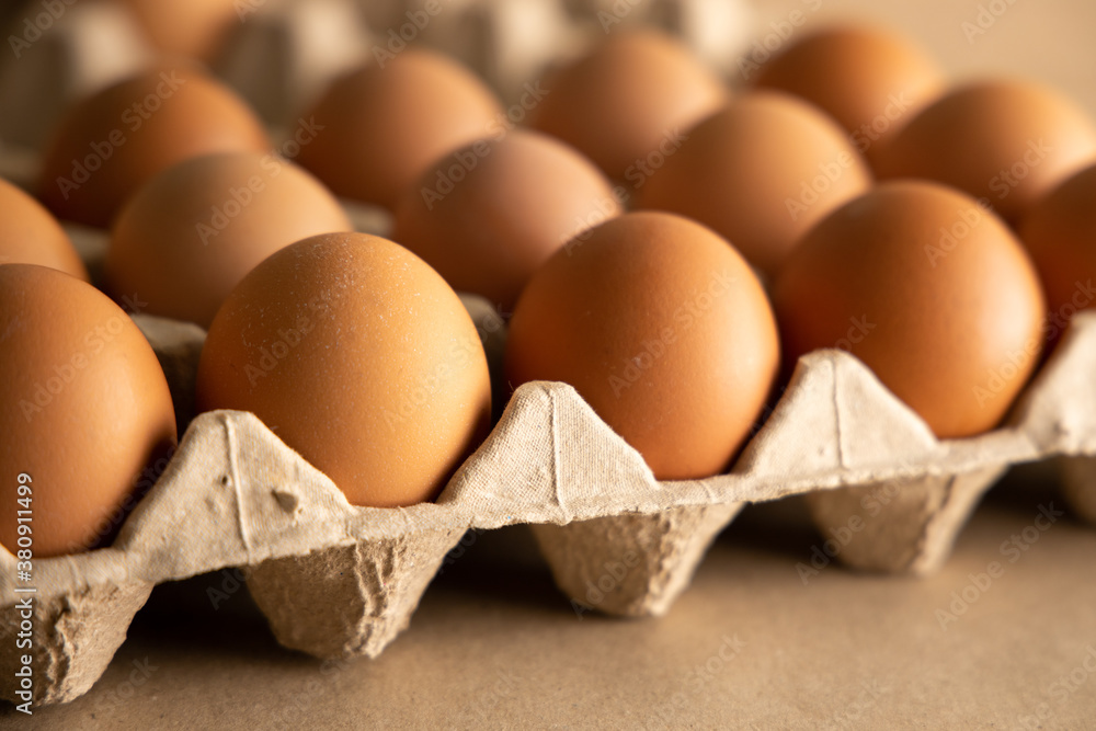 Close-up view of brown chicken eggs in carton egg crate on neutral background. Close-up view of brown chicken eggs in carton egg crate on neutral background.
