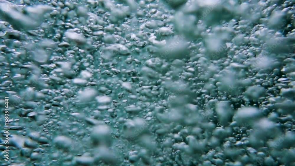 Bubbles rise from the depth to the surface in slow motion. They turbulize and dissolve in water. They pass close to the camera and propagate in defocus. 