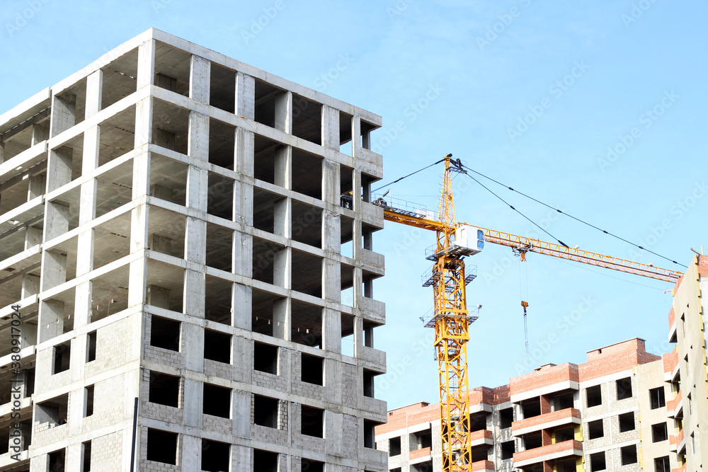 Fototapeta premium Crane and building construction site against blue sky