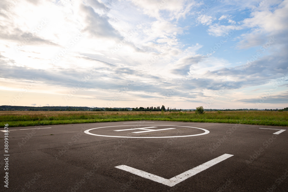 Fototapeta premium Hard surface for helicopter landing. Symbol for precise helicopter landing in the center. Evening landscape
