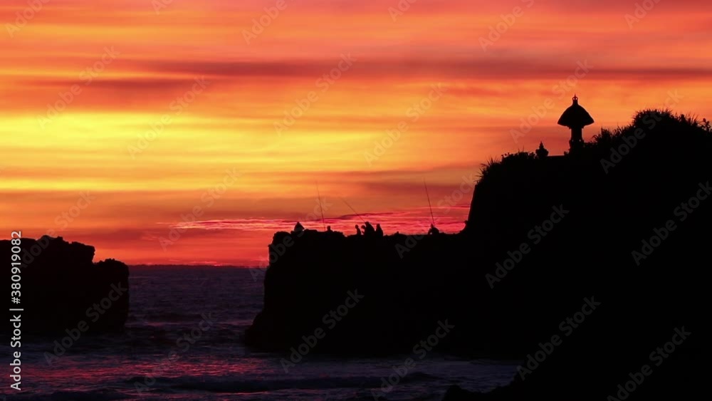 Insane sky with amazing colors with fisherman on the rocks and an ancient shrine to the side of them. Insane sky with amazing colors with fisherman on the rocks and an ancient shrine to the side of them.