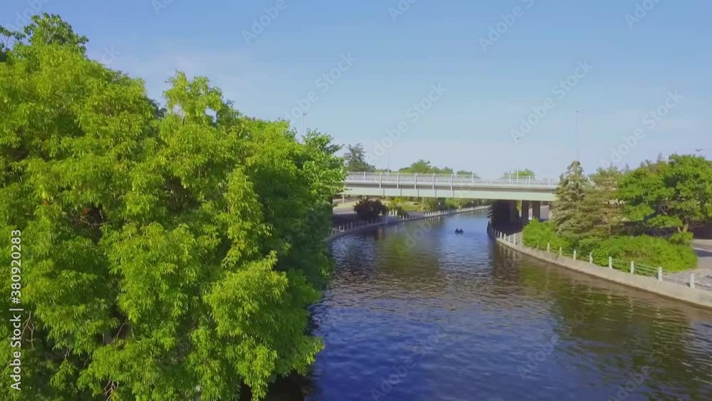 Peaceful craning shot of a bridge over a river revealing a couple in a paddle boat underneath. Peaceful craning shot of a bridge over a river revealing a couple in a paddle boat underneath.