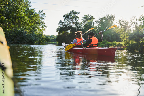 Beautiful young couple kayaking on lake