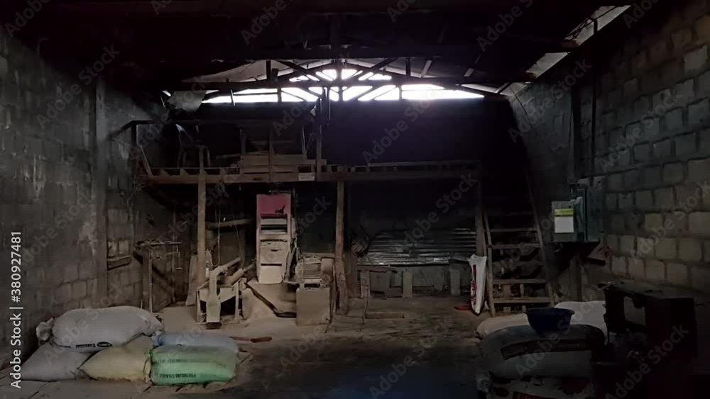 Inside a dark old rice mill with sacks on the floor. Inside a dark old rice mill with sacks on the floor.