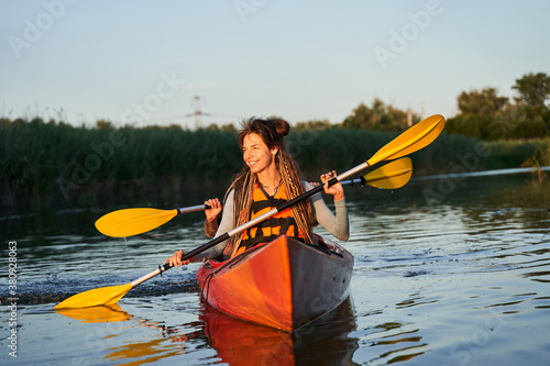 Happy family paddling kayak at sunset