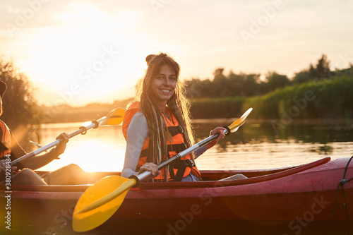 Smiling girl in canoe during sunset
