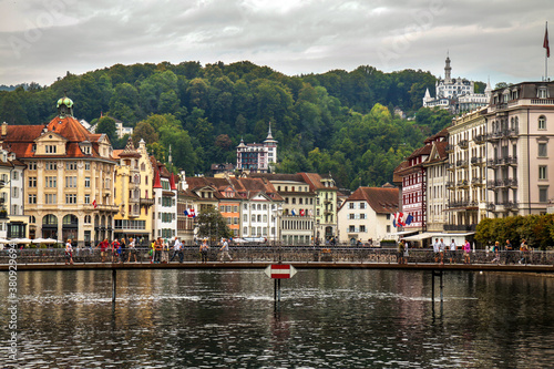 Lucerne, Switzerland: City hall bridge over the river Reuss in the old city; in the background wooded mountains and castles
