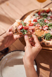 Woman hands picking slice of pizza