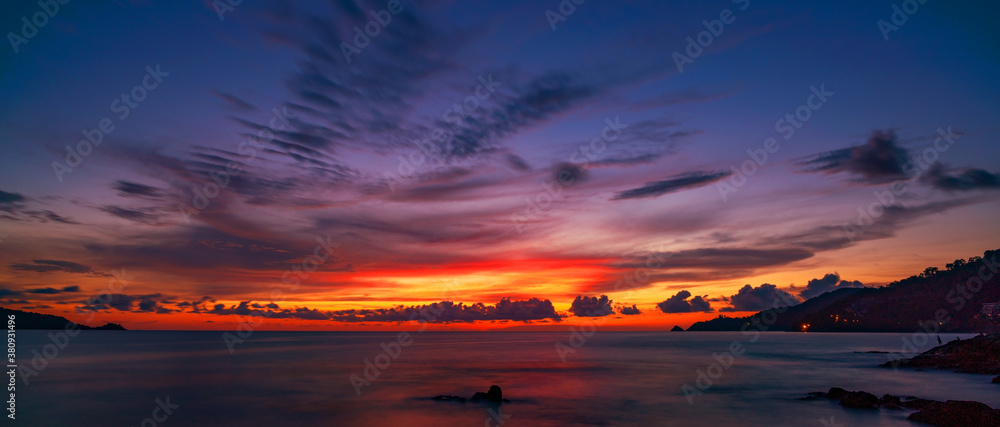 Landscape Long exposure of majestic clouds in the sky sunset or sunrise over sea with reflection in the tropical sea.