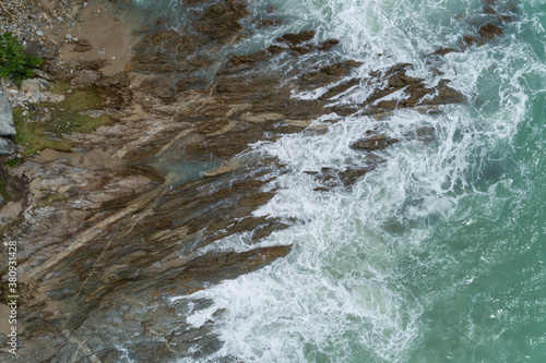 Aerial view of crashing waves on rocks landscape nature view and Beautiful tropical sea with Sea coast view in summer season image by Aerial view drone top down view. © panya99