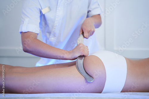 Therapist massaging female buttocks at the spa photo