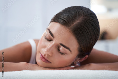Woman enjoying back massage with closed eyes