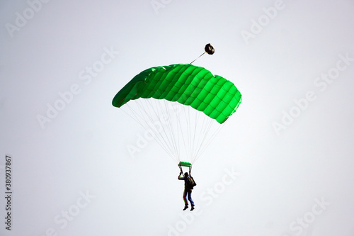 Closeup of a man parachuting with a green parachute during daylight photo