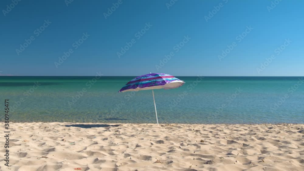 A lonely umbrella stands on the seashore. Strong wind blows from the sea. Deserted beaches after quarantine. Consequences of the pandemic. Abandoned beach.
A lonely umbrella stands on the seashore. Strong wind blows from the sea. Deserted beaches after quarantine. Consequences of the pandemic. Abandoned beach.