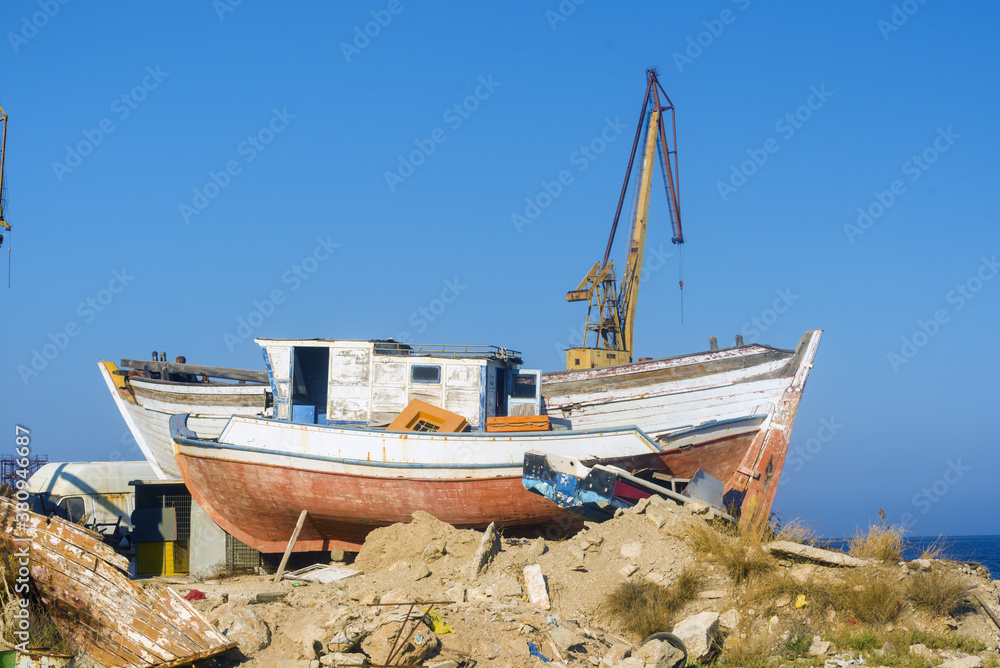 ruined boat and crane in Ermoupoli harbor, Syros island Greece