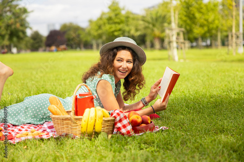 Young woman reading a book in the park. © dragonstock