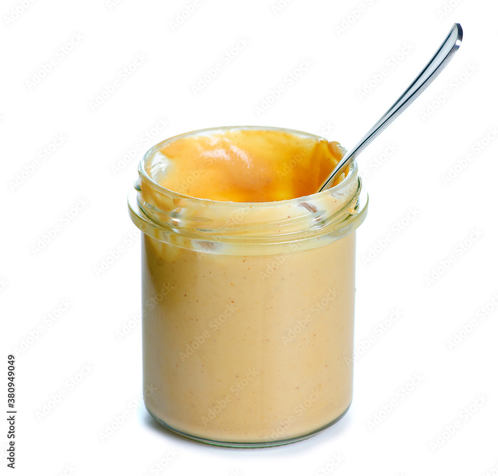 Jar with teaspoon peanut paste on white background isolation Jar with teaspoon peanut paste on white background isolation