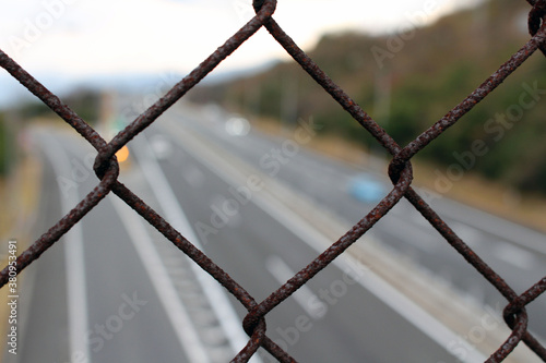 Fence overlooking blurred Japanese highway, taken in Beppu