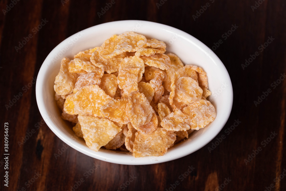 Breakfast cereal in a white cup on a wooden floor Breakfast cereal in a white cup on a wooden floor
