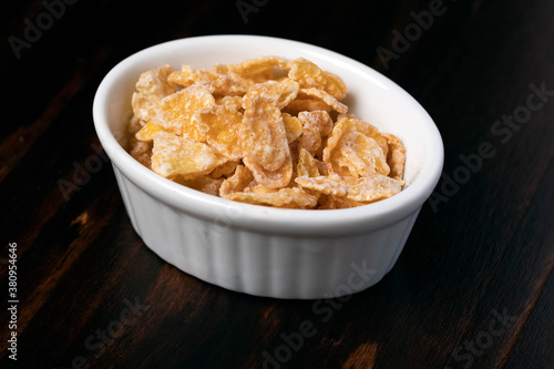 Breakfast cereal in a white cup on a wooden floor