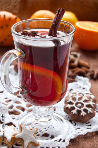 Hot red mulled wine with christmas spices and cookies, orange, anise and cinnamon sticks