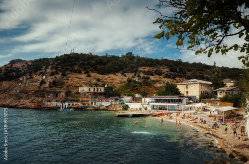 Crimea, Bay with beach and sea, people swim.